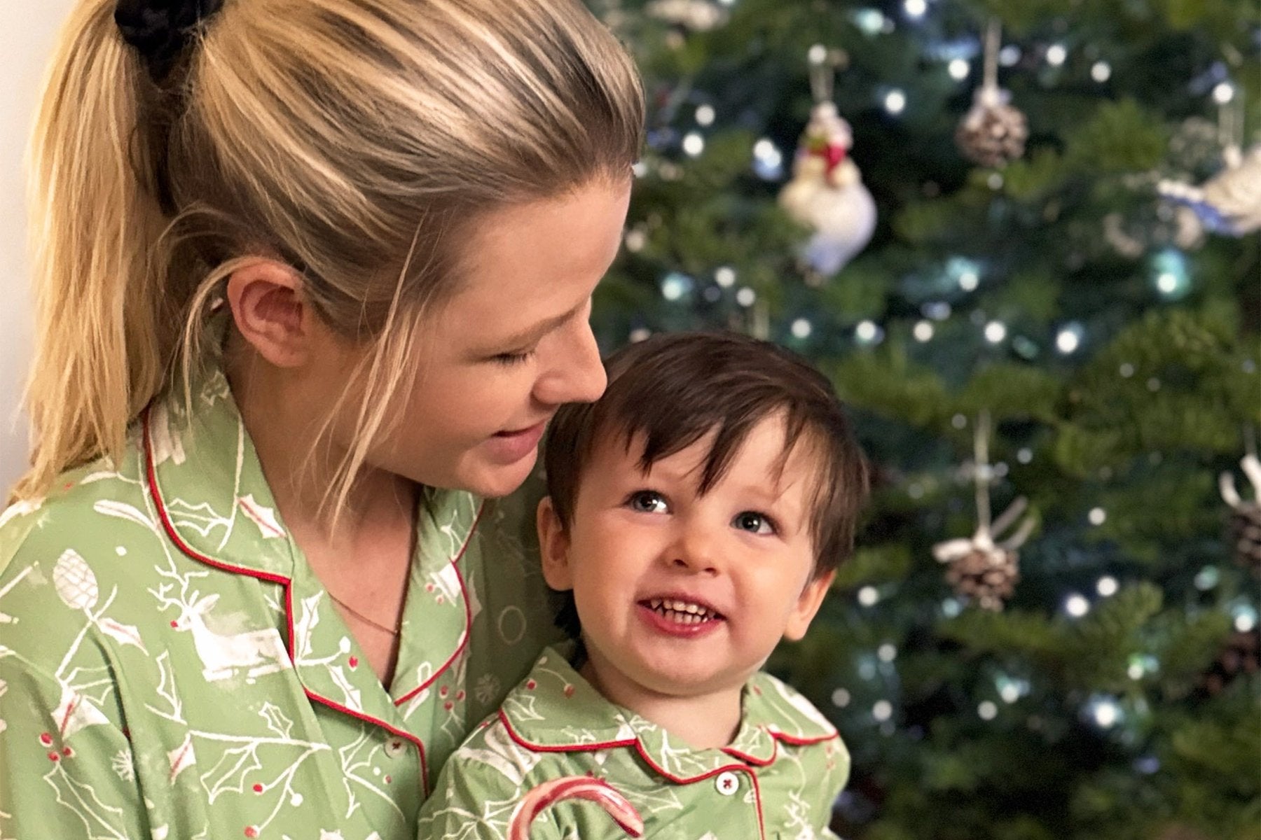 Mum and toddler in matching Atlas & Maya Evergreen Tale bamboo Christmas pajamas by the Christmas tree